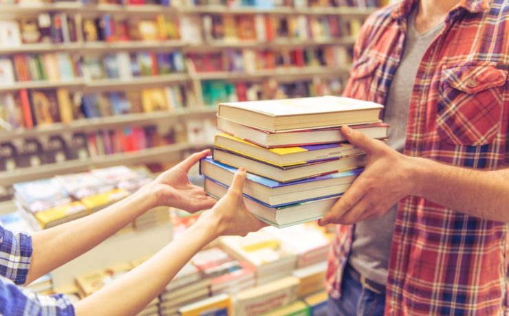 Person handing over new books to read for New Year's Resolution.