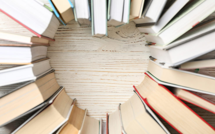 Heart made of books on white wooden rustic background